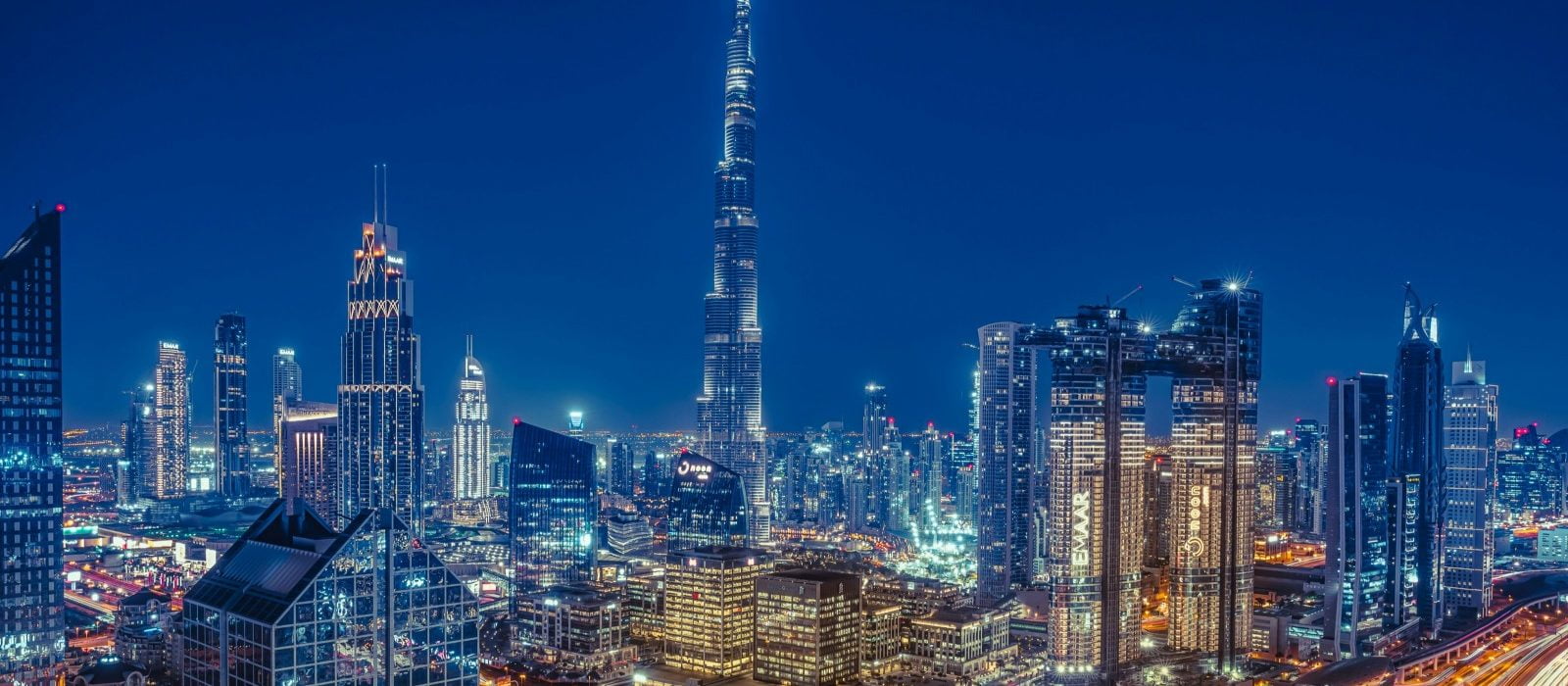 Top 10 DIFC Bars in Dubai City View at night, skyscraper and lights and a glowing highway